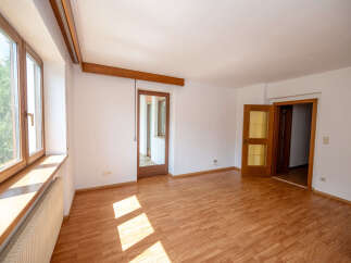 This spacious room features a large wooden-framed window with a wide windowsill, perfect for natural light and decor.