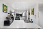 Discover this charming kitchen, perfect for coffee lovers, featuring a 'Desert Sun Coffee Roasters' sign and a convenient coffee maker.