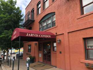 Discover comfortable living at Jarvis Condos, featuring a welcoming entrance with a prominent awning and double doors.