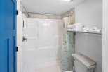 Step into this clean and bright bathroom featuring a spacious white shower stall with a convenient handheld showerhead.