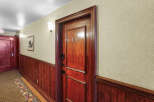 Step into this charming hallway featuring a beautifully crafted wooden door with the number 106 prominently displayed.