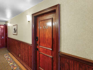 Step into this charming hallway featuring a beautifully crafted wooden door with the number 106 prominently displayed.