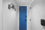 Enhance your home's security and style with this modern entryway featuring a vibrant blue door and a sleek black smart lock.