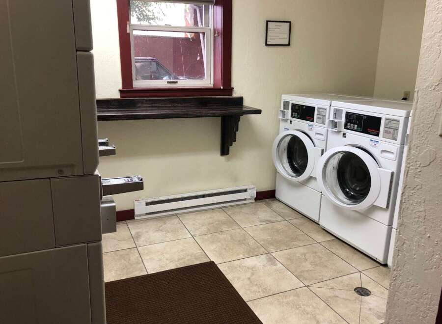 Discover the convenience of this well-equipped laundry room, featuring two commercial-grade washing machines ready for your use.
