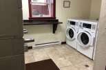 Discover the convenience of this well-equipped laundry room, featuring two commercial-grade washing machines ready for your use.