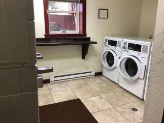 Discover the convenience of this well-equipped laundry room, featuring two commercial-grade washing machines ready for your use.