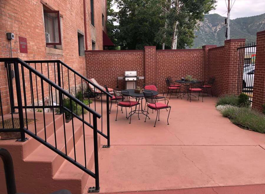 Enjoy outdoor living with this charming patio featuring a gas grill and comfortable seating.