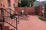 Enjoy outdoor living with this charming patio featuring a gas grill and comfortable seating.