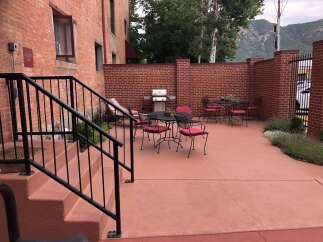 Enjoy outdoor living with this charming patio featuring a gas grill and comfortable seating.