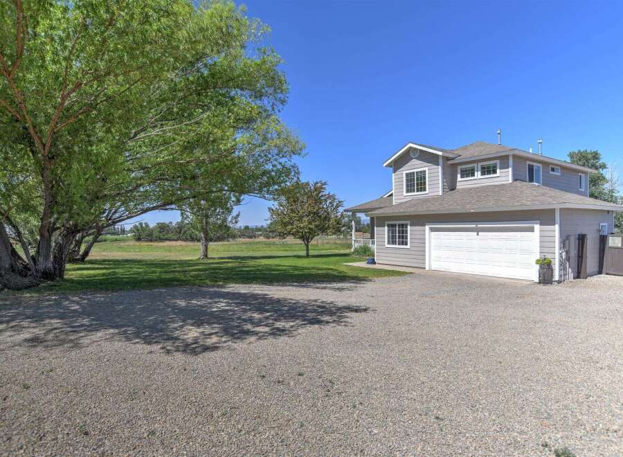Discover this charming two-story home featuring a spacious gravel driveway leading to an attached two-car garage.