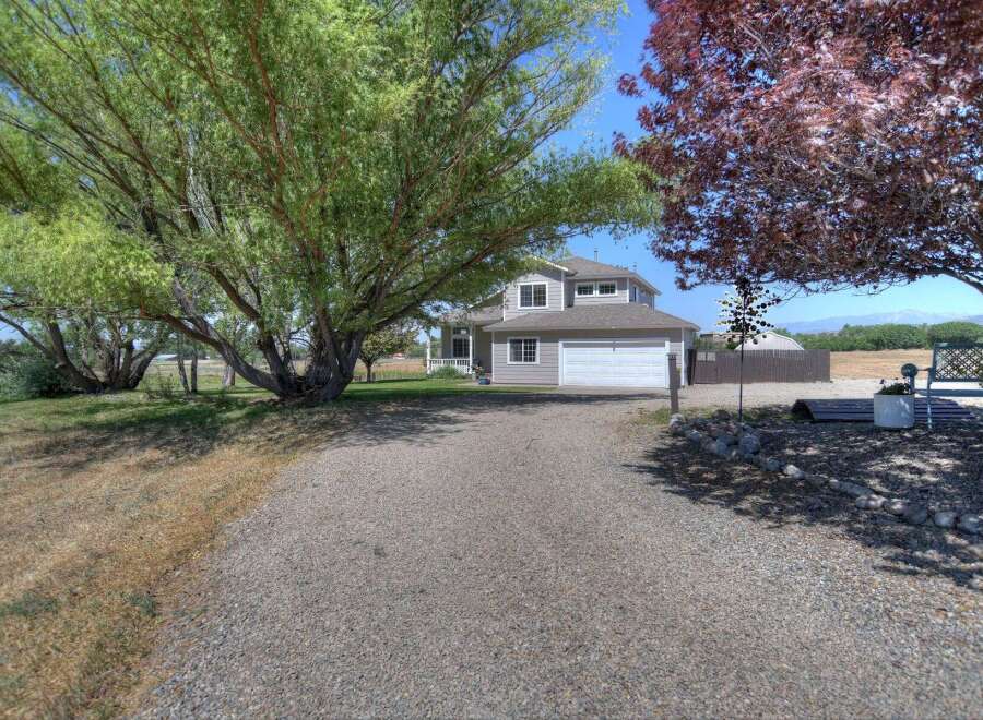 Discover this charming home with a welcoming gravel driveway leading to a spacious two-car garage.
