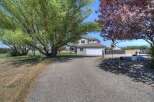 Discover this charming home with a welcoming gravel driveway leading to a spacious two-car garage.