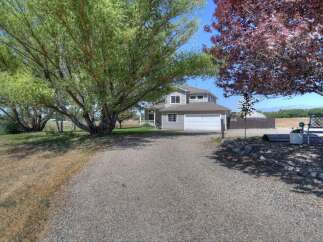 Discover this charming home with a welcoming gravel driveway leading to a spacious two-car garage.