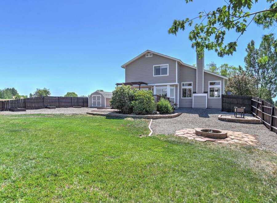 Enjoy outdoor living in this spacious backyard featuring a fire pit area perfect for gatherings and a convenient shed for storage.
