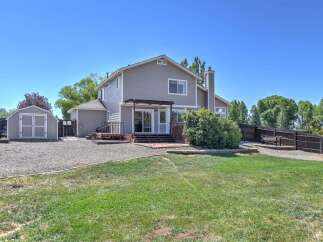 This spacious backyard offers a perfect blend of relaxation and utility, featuring a multi-level wooden deck ideal for entertaining and a charming garden shed for storage.