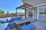 Enjoy outdoor living on this spacious deck, complete with a comfortable sectional sofa and a dining table perfect for al fresco meals.