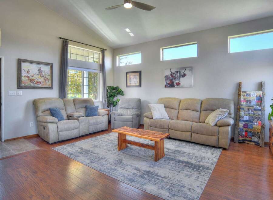 Step into this inviting living room featuring comfortable reclining sofas and a unique wooden coffee table, perfect for gatherings.