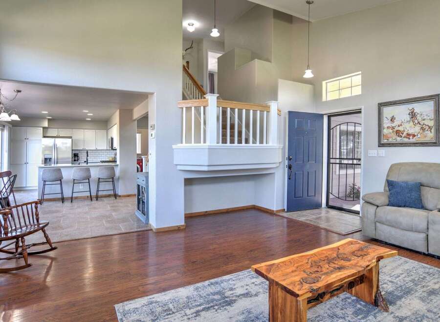 Step into this inviting living space featuring a spacious open-concept layout that seamlessly connects to a modern kitchen with ample cabinet space and a breakfast bar.