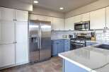 This kitchen boasts a modern aesthetic with crisp white upper cabinets contrasting beautifully with the serene blue lower cabinets.