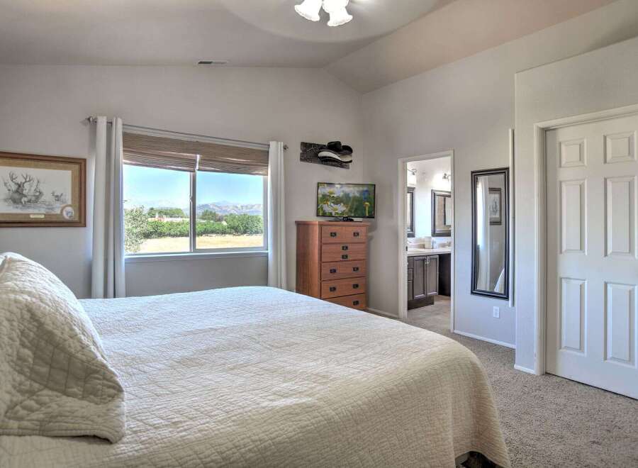 Experience comfort and convenience in this inviting bedroom, featuring a large window with stunning mountain views.