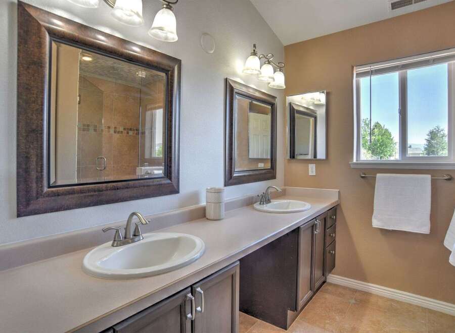 This spacious bathroom features a double vanity with two sinks and ample counter space, perfect for busy mornings.