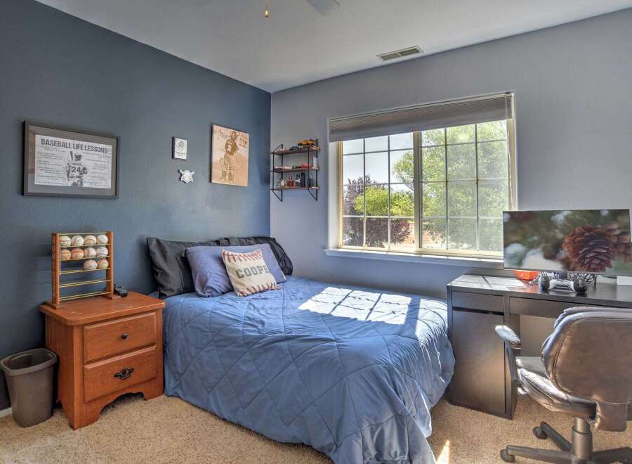 This charming bedroom features a comfortable blue comforter on the bed, perfect for a restful night's sleep.