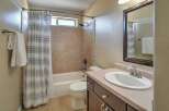 This bathroom features a bathtub/shower combo with tiled walls and a decorative mosaic tile accent.