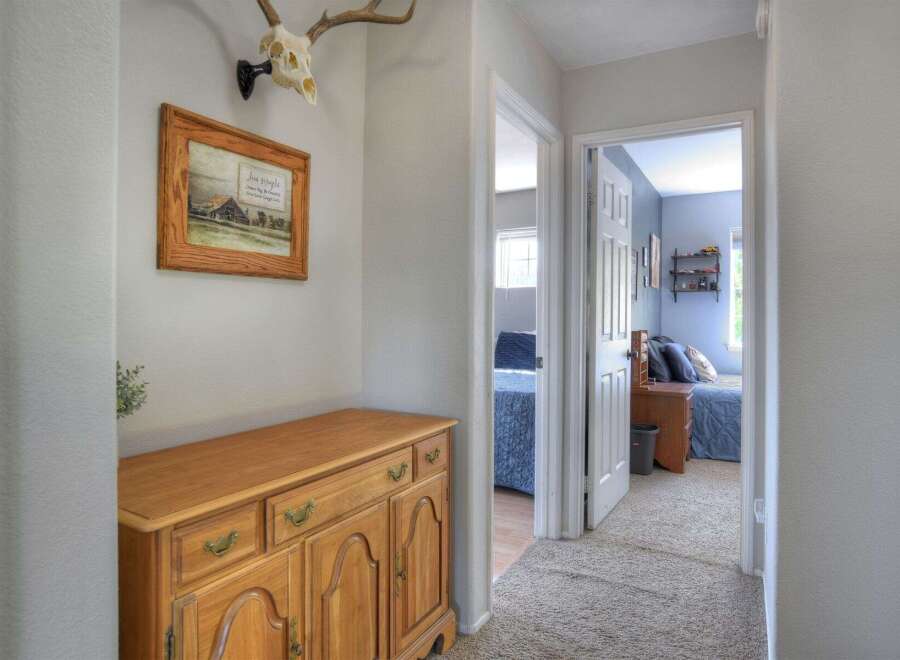 Step into this charming hallway featuring a rustic wooden dresser and a unique deer skull mount, adding a touch of character.