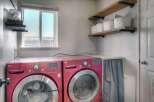 This laundry room features a pair of vibrant red LG front-load washers, offering ample capacity for your laundry needs.