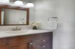 This bathroom features a stylish dark wood vanity with silver hardware, complemented by a white countertop and sink.