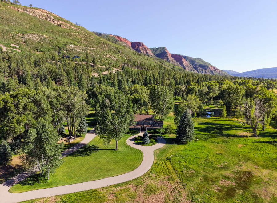 Nestled amidst a lush forest and rolling green hills, this stunning property offers a serene escape with breathtaking mountain views.