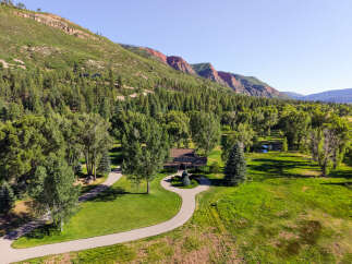 Nestled amidst a lush forest and rolling green hills, this stunning property offers a serene escape with breathtaking mountain views.