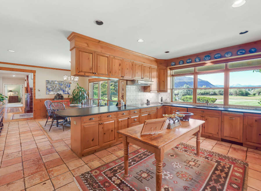 This spacious kitchen boasts custom wood cabinetry and a large island, perfect for meal preparation and casual dining.