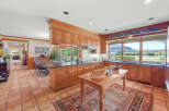 This spacious kitchen boasts custom wood cabinetry and a large island, perfect for meal preparation and casual dining.
