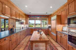 Experience the charm of this spacious kitchen, featuring warm wooden cabinetry and a large central island perfect for meal preparation and gathering.