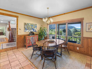 Enjoy breathtaking mountain views from this charming dining room, featuring a rustic wooden table and chairs perfect for intimate gatherings.