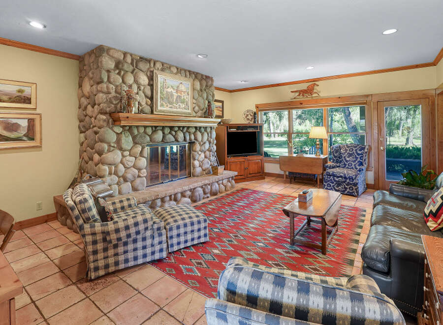 Experience rustic charm in this inviting living room, featuring a grand stone fireplace as the centerpiece.