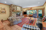 Experience rustic charm in this inviting living room, featuring a grand stone fireplace as the centerpiece.