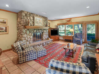 Experience rustic charm in this inviting living room, featuring a grand stone fireplace as the centerpiece.