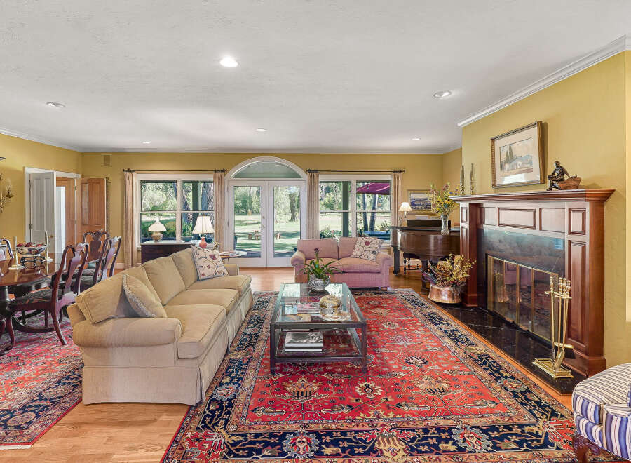 Step into this elegant living room featuring a grand piano and a cozy fireplace, perfect for entertaining.