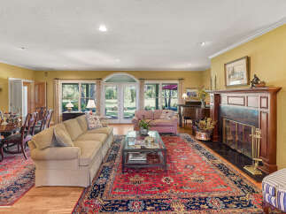 Step into this elegant living room featuring a grand piano and a cozy fireplace, perfect for entertaining.