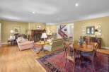 This spacious living and dining area features a beautiful grand piano, a cozy fireplace, and a formal dining set perfect for entertaining.