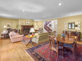 This spacious living and dining area features a beautiful grand piano, a cozy fireplace, and a formal dining set perfect for entertaining.