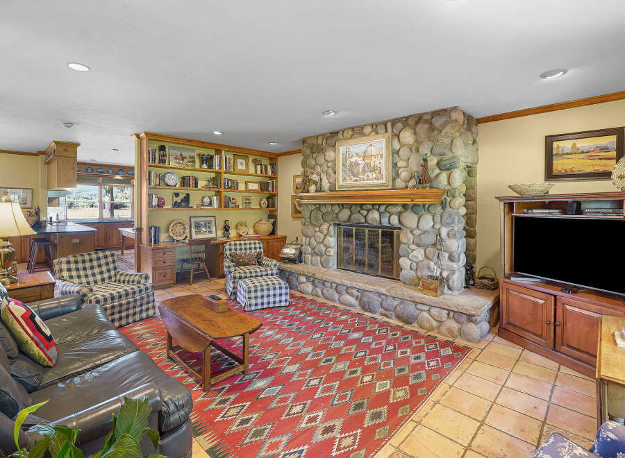 Step into this inviting living room, featuring a grand stone fireplace as the centerpiece, perfect for cozy evenings.