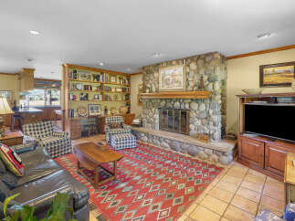 Step into this inviting living room, featuring a grand stone fireplace as the centerpiece, perfect for cozy evenings.