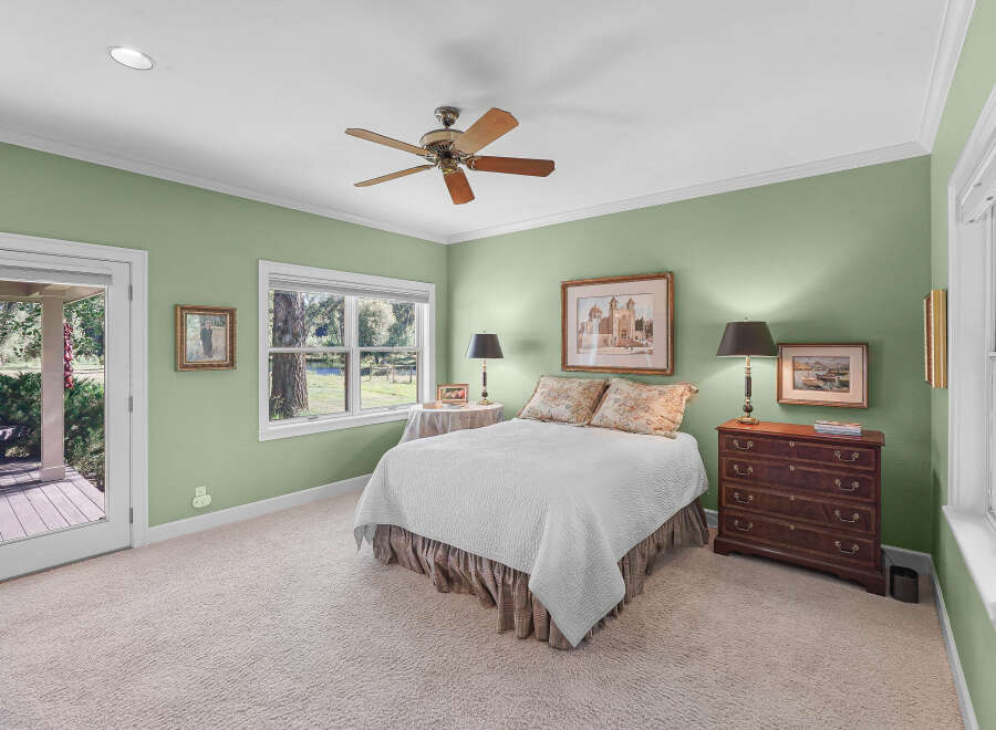 This charming bedroom features a comfortable queen-size bed adorned with a white quilted comforter and floral accent pillows.