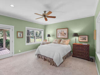 This charming bedroom features a comfortable queen-size bed adorned with a white quilted comforter and floral accent pillows.