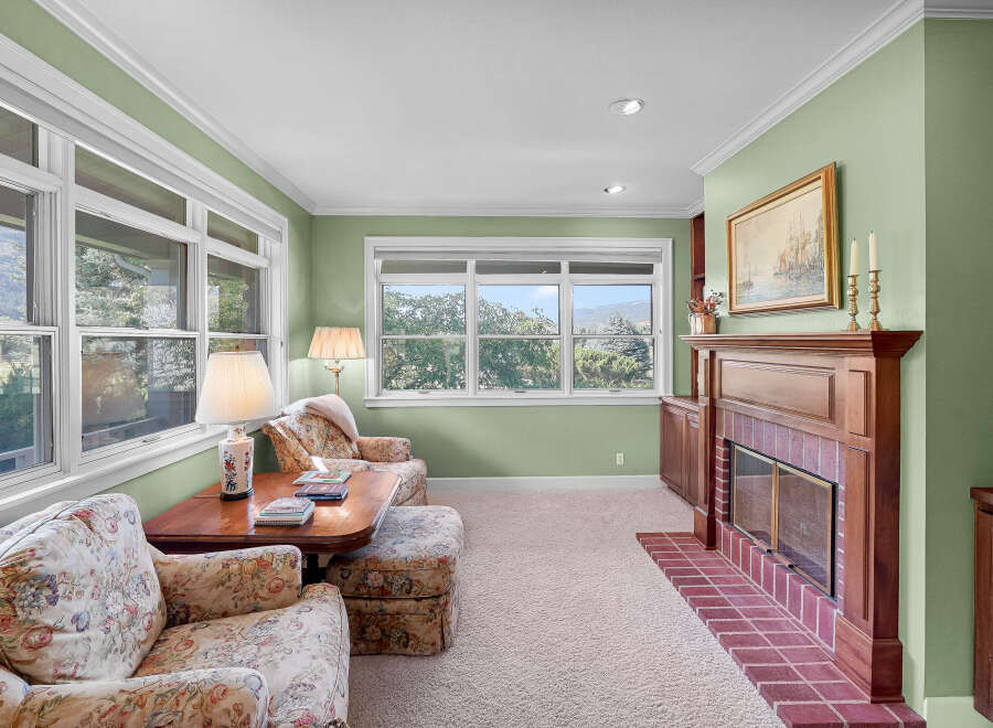 Step into this charming living room, bathed in natural light from large windows offering serene views of the surrounding landscape.