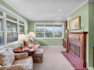 Step into this charming living room, bathed in natural light from large windows offering serene views of the surrounding landscape.