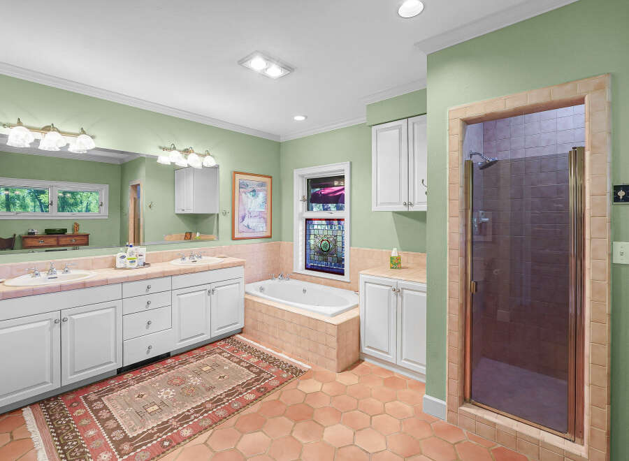 This spacious bathroom features a large vanity with dual sinks and ample storage, perfect for any household.